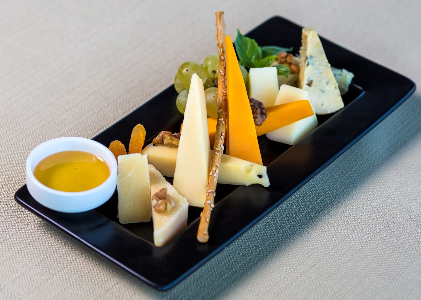 A visually appealing cheese platter featuring various cheeses, nuts, and fruits in a close-up shot.